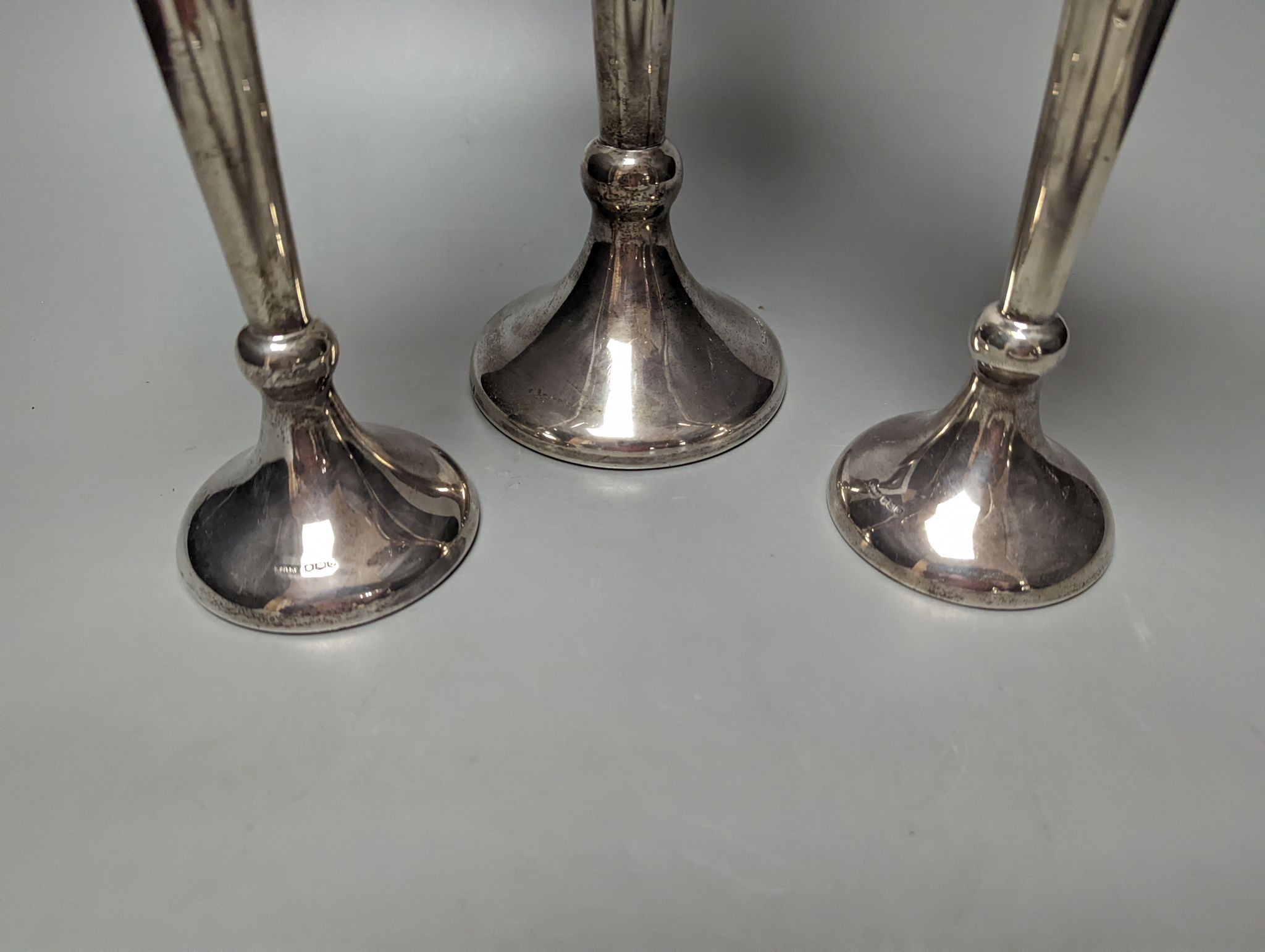 A large George V silver mounted trumpet vase, 34cm and a pair of smaller silver mounted vases.